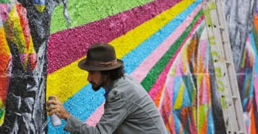 Homem fazendo de piche pintura em muro