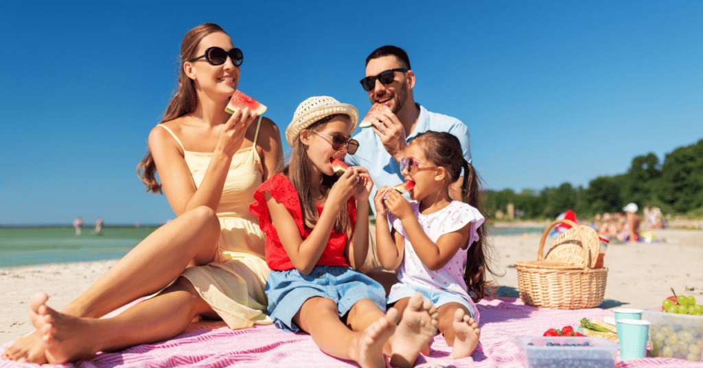 Família comendo na praia.