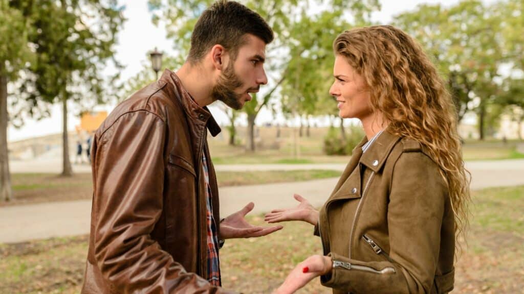 Um homem e uma mulher conversando no meio de uma praça.