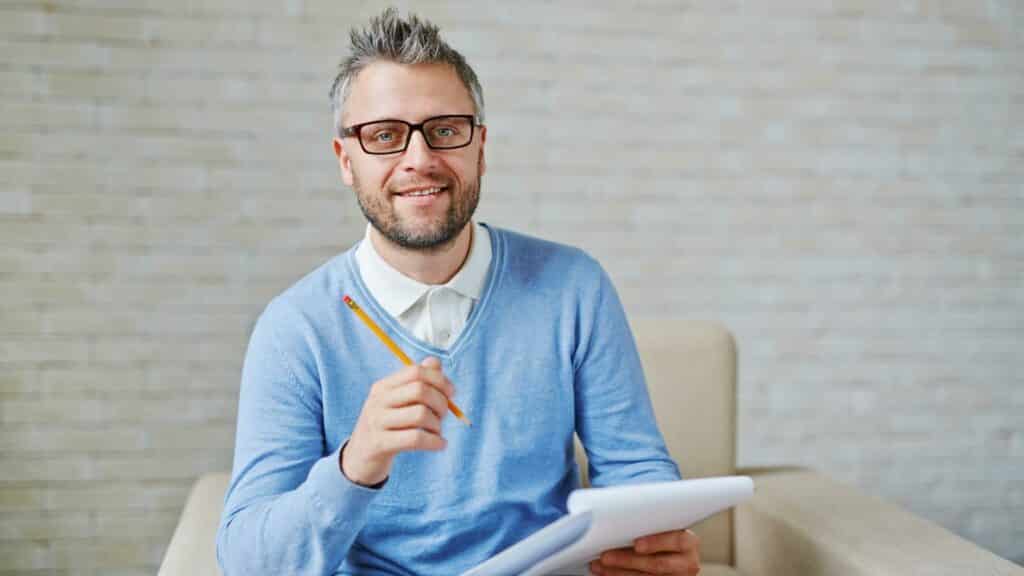 Um homem segurando um lápis e um bloco de notas