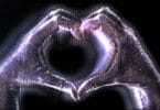 Mãos com brilho holográfico em sinal de coração