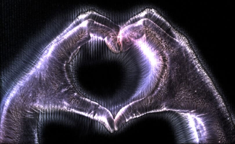 Mãos com brilho holográfico em sinal de coração