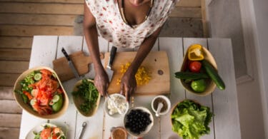 Mulher cozinhando vegetais.