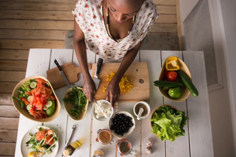 Mulher cozinhando vegetais.