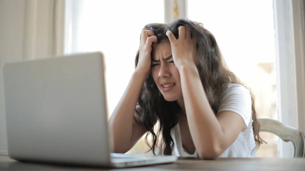 Uma mulher com raiva em frente a um computador.
