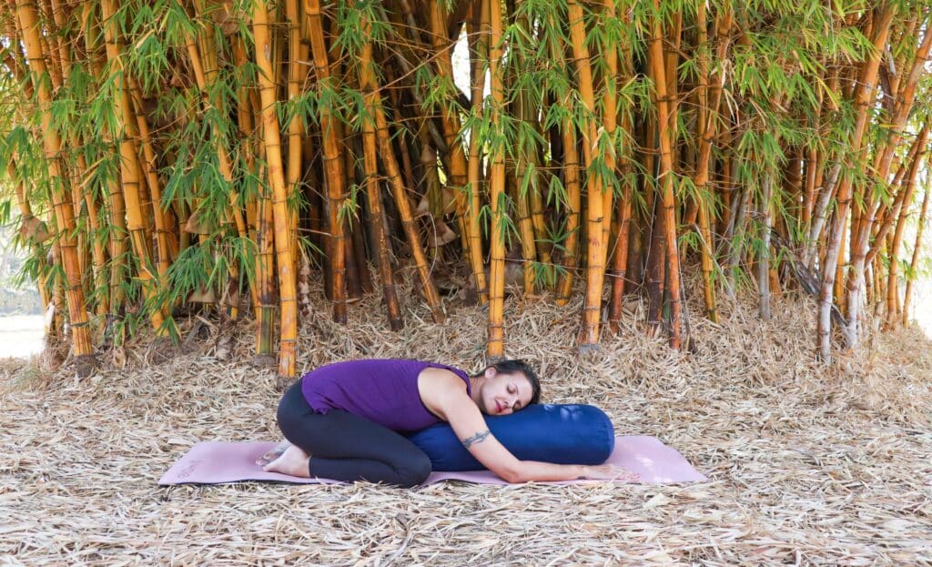 Mulher fazendo a posição da criança no Yoga.