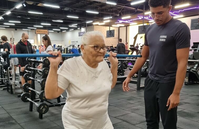 Dona Raimunda realizando atividades físicas numa academia.