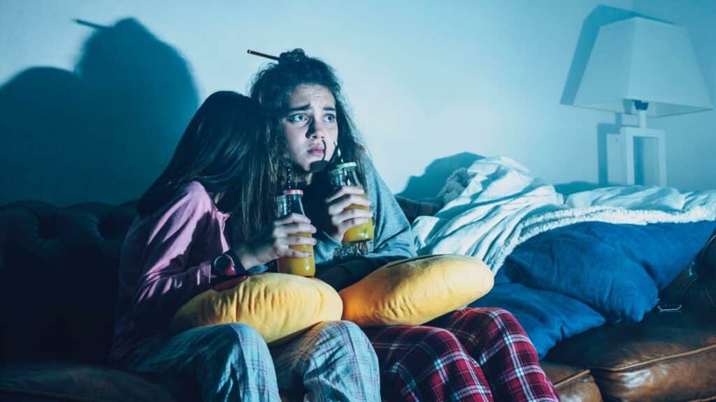 Duas garotas assustadas assistindo um filme.