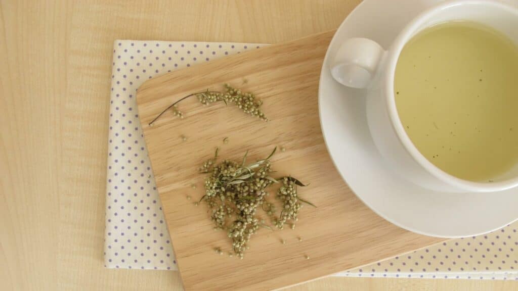 Uma xícara de chá de artemísia numa tábua.
