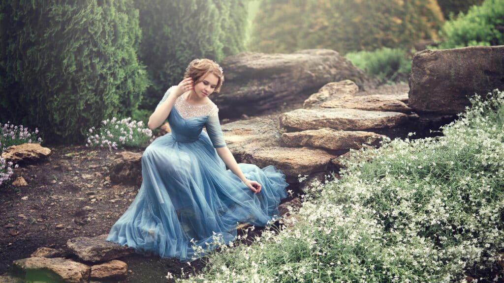 Uma mulher com um vestido azul num campo de flores.