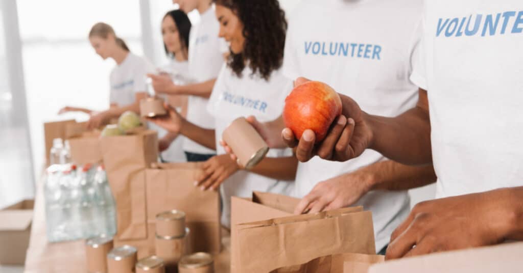 Voluntários ajudando em evento de doação alimentícia.