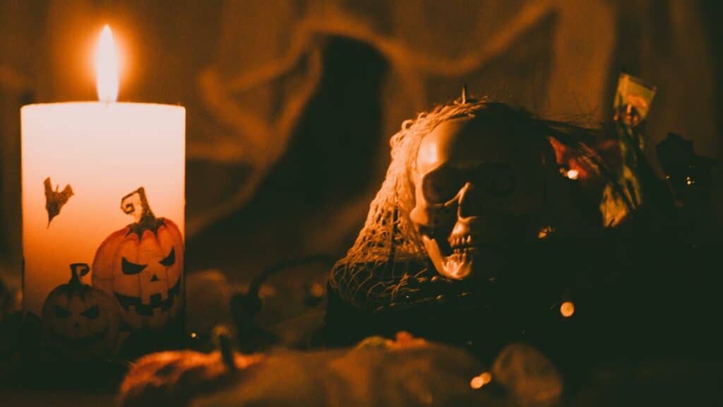 Uma decoração de Dia das Bruxas. Vê-se, nesta, uma vela ilustrada com uma abóbora e um crânio humano.