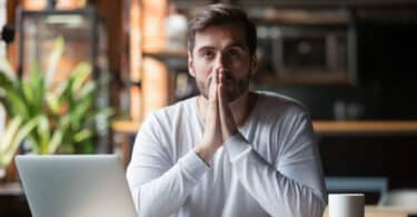 Um homem, num ambiente de trabalho, exibindo um rosto pensativo.