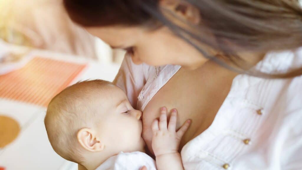 Uma mulher amamentando o seu bebê.