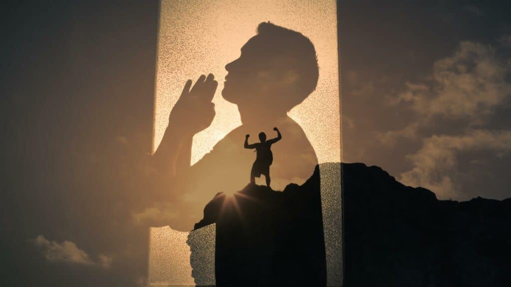 Uma silhueta de um homem fazendo preces ao céu. Ao fundo, um homem de braços erguidos à beira de um precipício. 