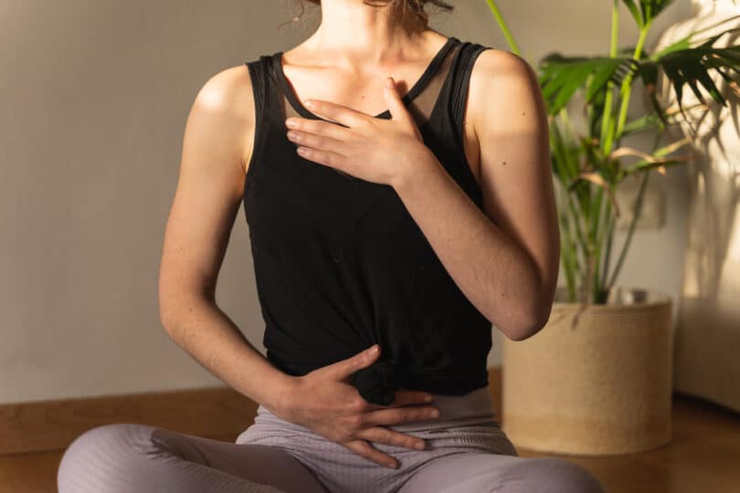 Uma mulher realizando respiração consciente.