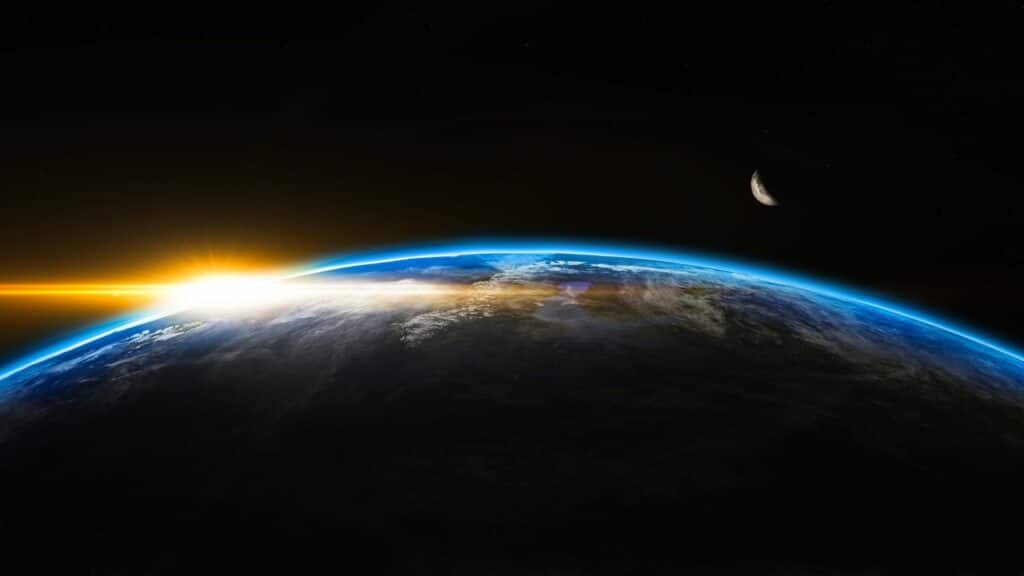 Uma superfície do planeta Terra. À esquerda, uma luz a irradia.