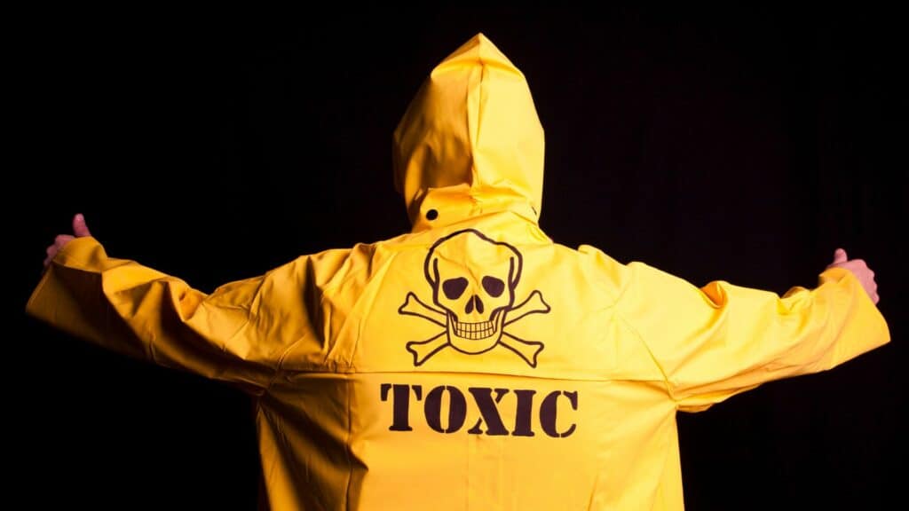 Uma pessoa vista de costas com uma capa com uma caveira e a palavra "toxic" escrita nela.