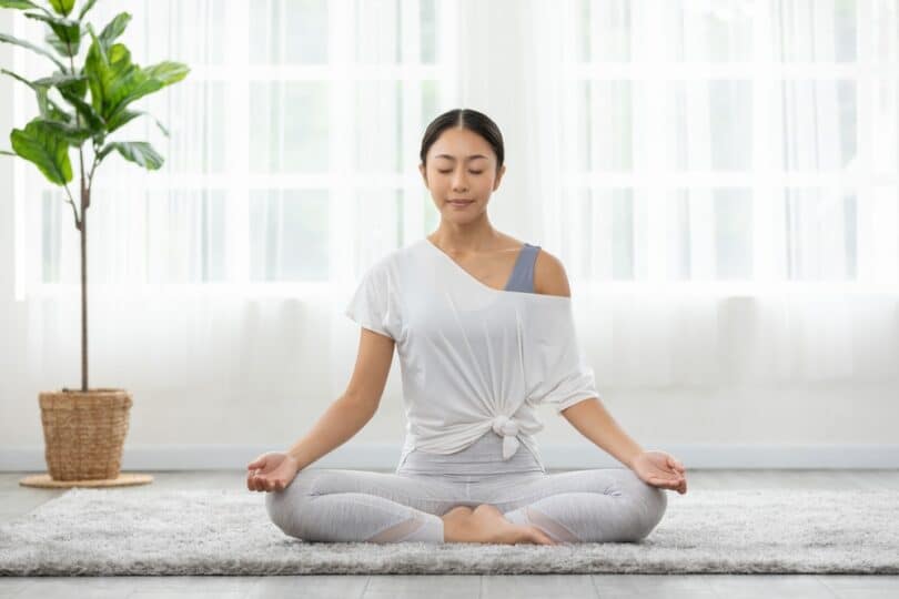 Uma mulher meditando.