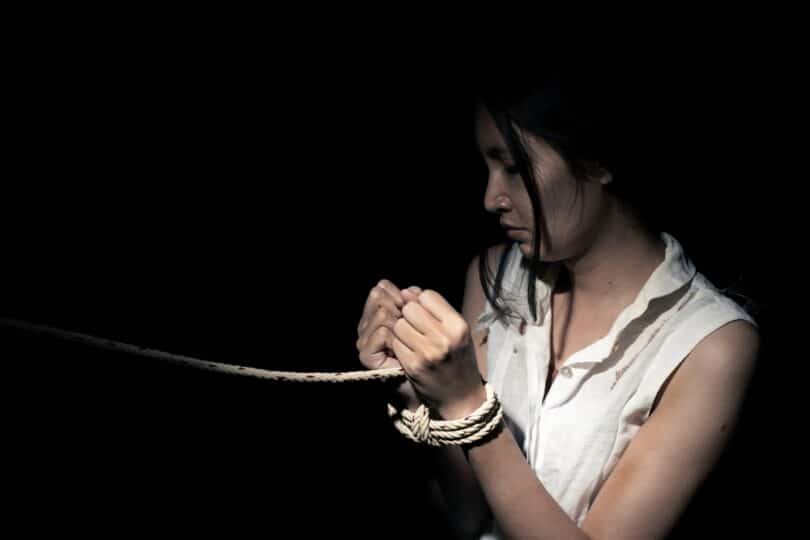 Uma mulher presa às cordas.