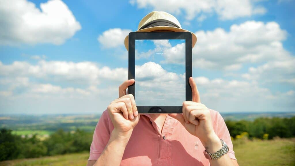 Um homem segurando um tablet que exibe a imagem do céu.