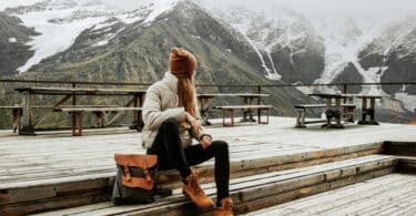 Uma mulher contemplando montanhas repletas de neve.