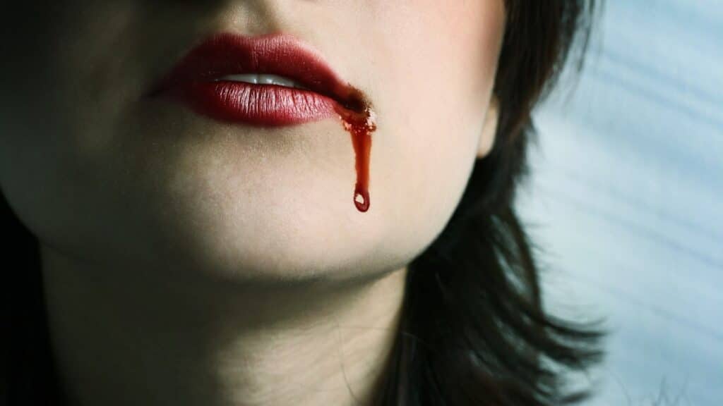Uma mulher cujo canto esquerdo da boca sangra.