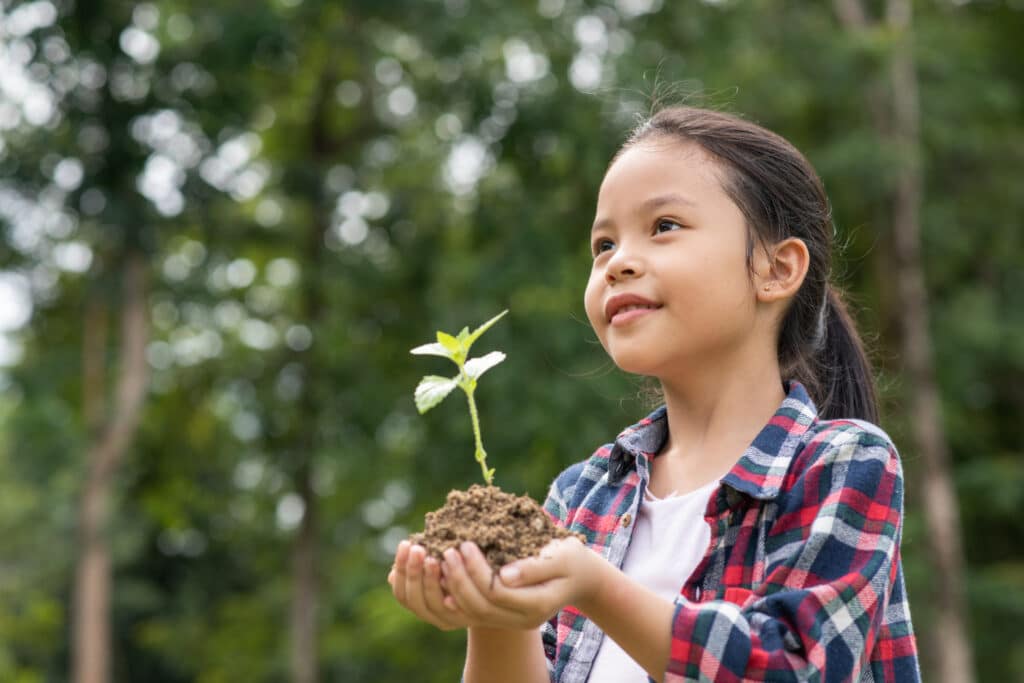 Menina segurando uma muda de planta