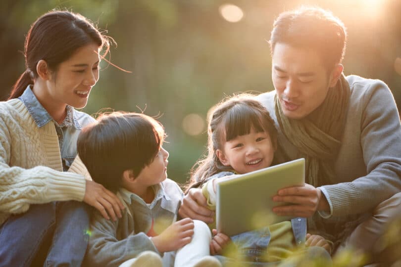 Uma família asiática observando fotografias.