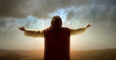 Jesus Cristo de braços erguidos observando o céu.