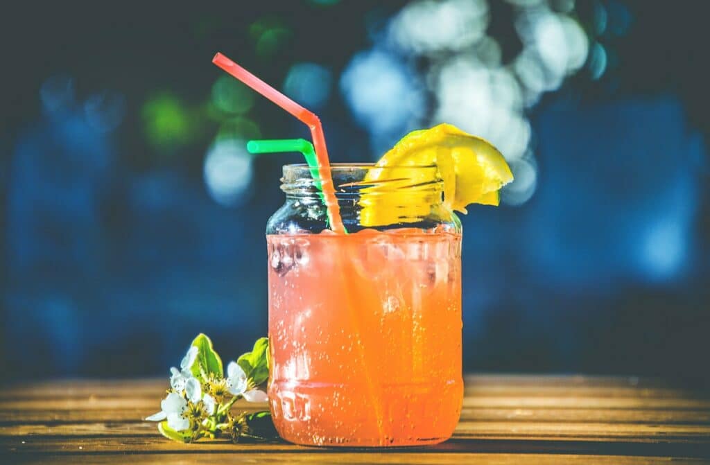 Drink laranja com canudos coloridos