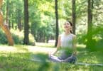 Mulher asiática meditando na natureza