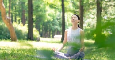 Mulher asiática meditando na natureza