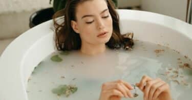 Imagem de uma mulher tomando banho de ervas na banheira