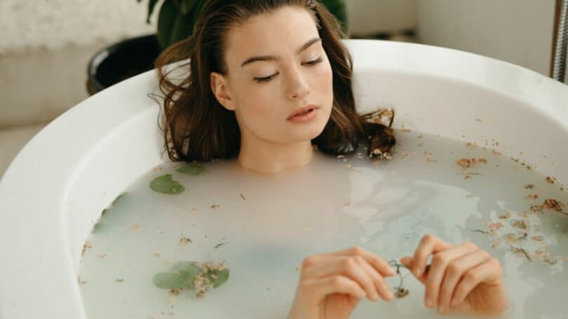 Imagem de uma mulher tomando banho de ervas na banheira