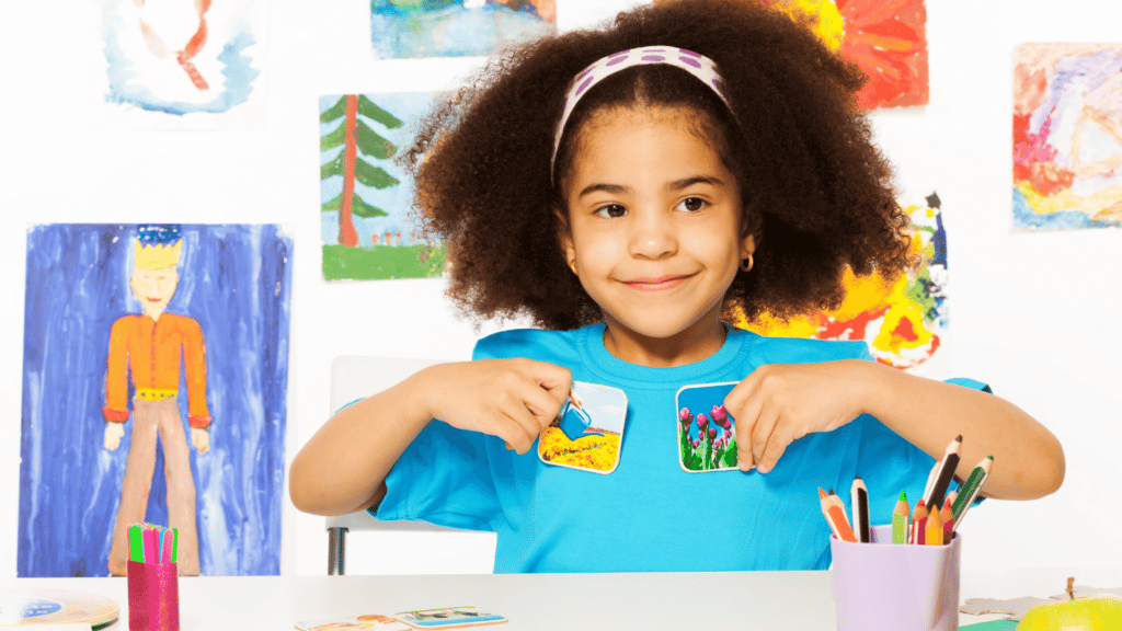 Menina negra brincando com figuras em uma mesa.