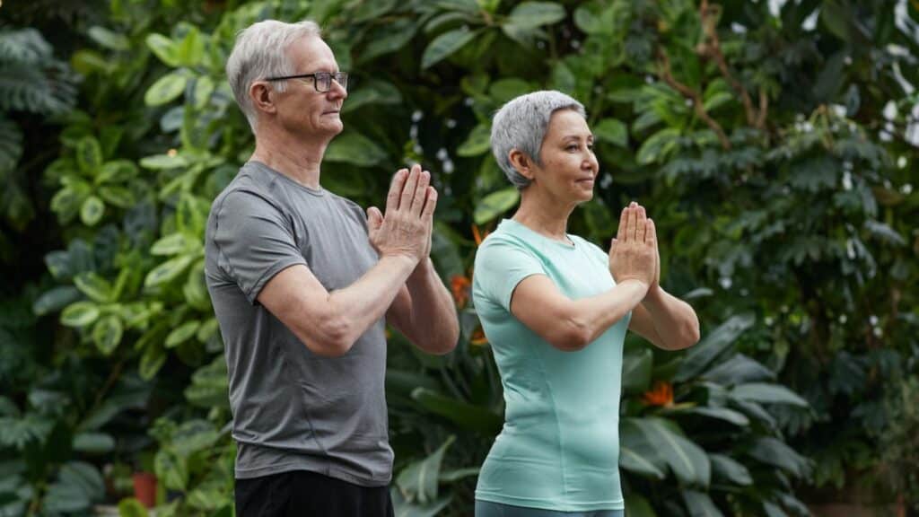 Foto de um casal de meia idade fazendo Yoga.