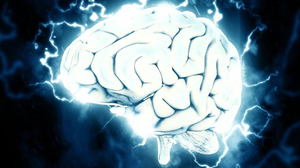 Imagem de um cérebro com efeitos ilustrativos em azul com elementos parecidos com raios ao redor