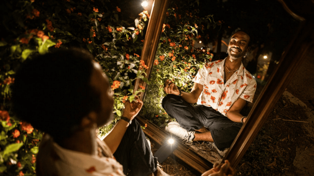 Homem olhando seu reflexo no espelho e sorrindo.