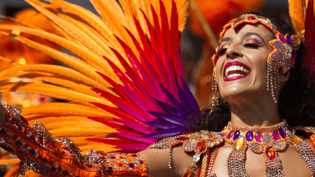 Mulher desfilando no carnaval de Notting Hill com roupa típica.