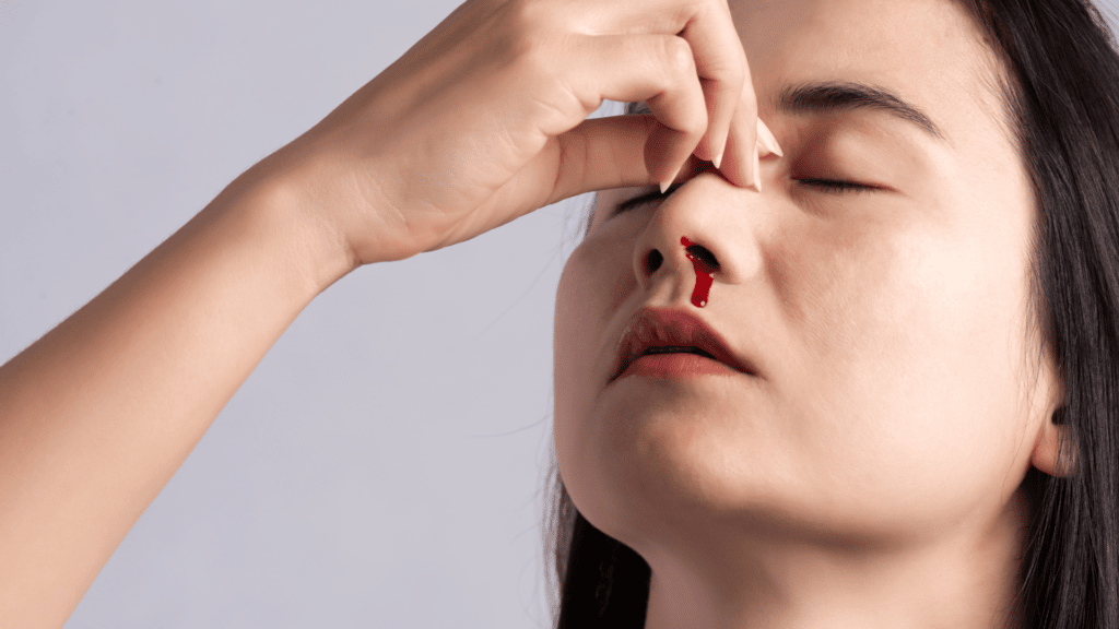 Mulher asiática com o nariz sangrando
