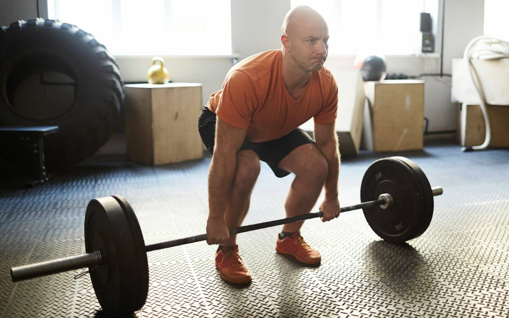 Um homem realizando um levantamento terra durante uma sessão de musculação.