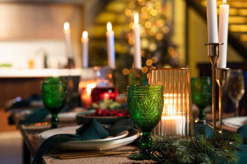 Mesa decorada para a noite de Ano Novo, com velas e copos temáticos.