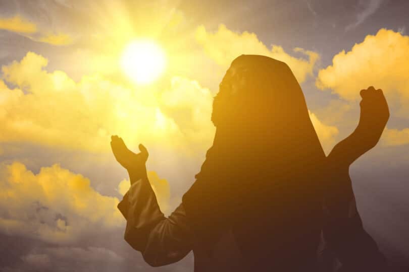 Imagem de uma santa orando com as mãos para cima.