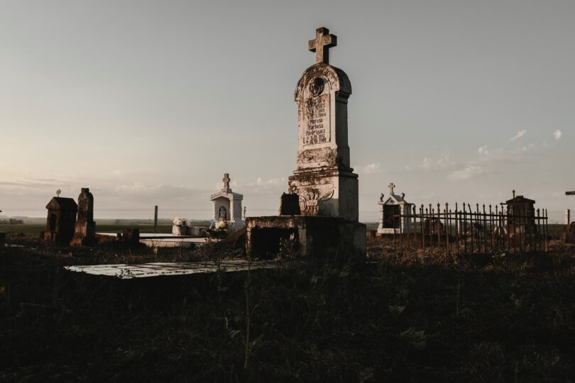 Cemitério, com foco em um túmulo aleatório.