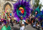 Homem dançando com uma fantasia no Notting Hill Carnival