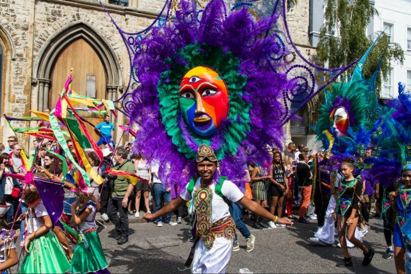 Homem dançando com uma fantasia no Notting Hill Carnival