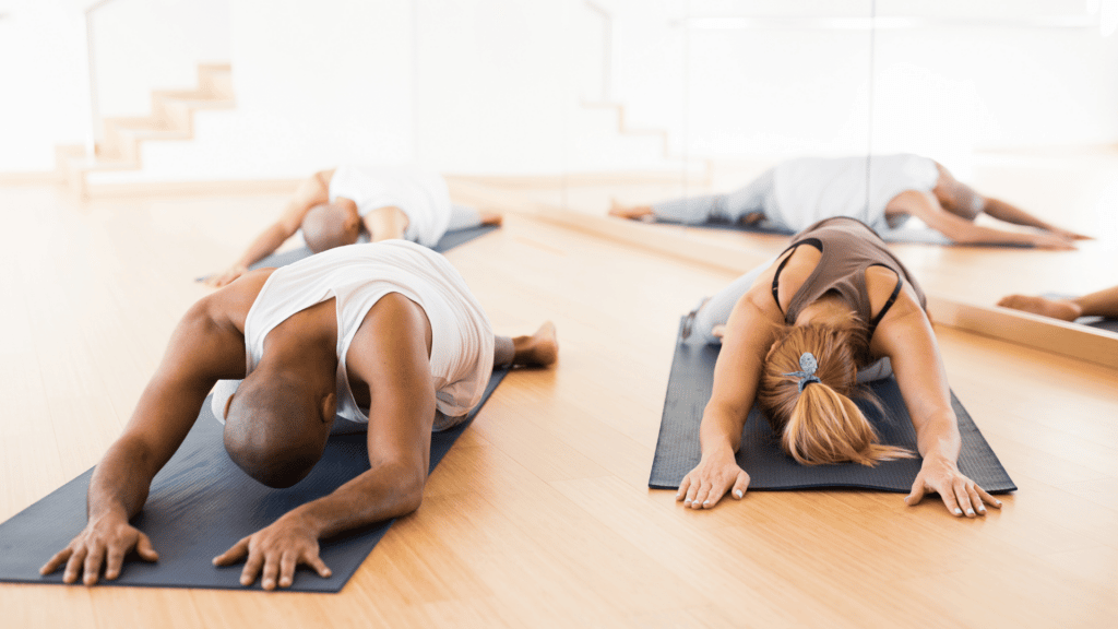 Casal praticando yoga com a postura da criança.