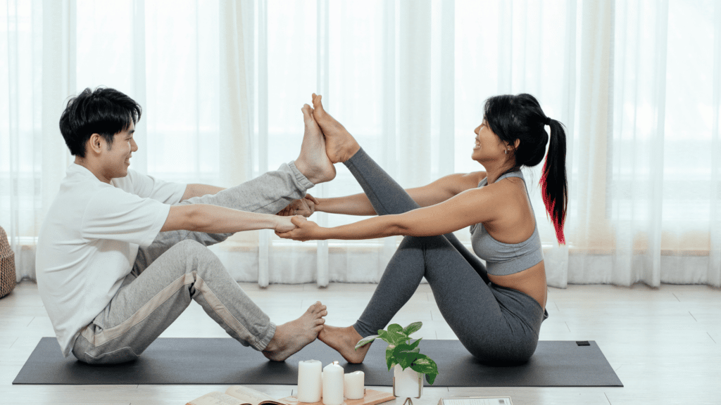 Casal asiático praticando yoga com a postura do barco