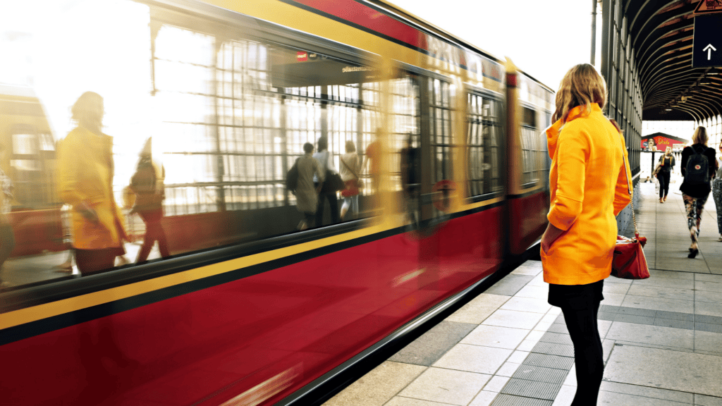 Pessoas esperando em estação enquanto o trem está em movimento